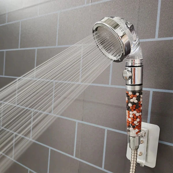 Chuveiro de mão filtrante em parede de azulejos cinza