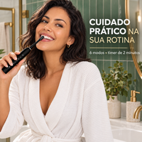 Mulher usando escova elétrica em banheiro verde