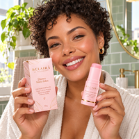 Mulher brasileira sorridente apresentando o bálsamo Belaira com sua caixa